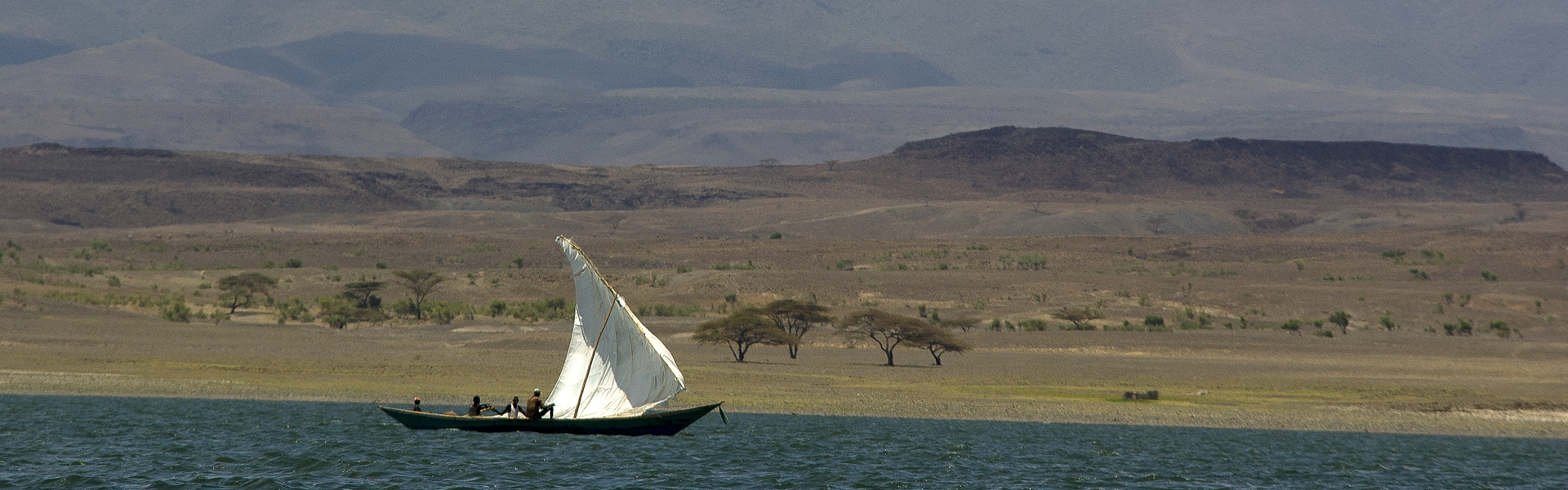 Fisherman in canoe plowing through the waters of Lake Turkana