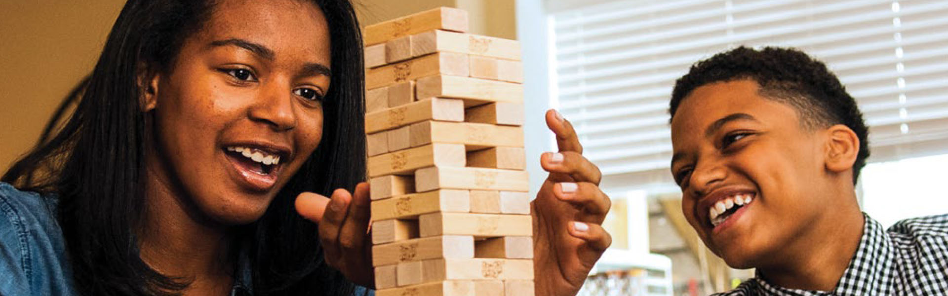 Woman and child playing with wooden blocks.