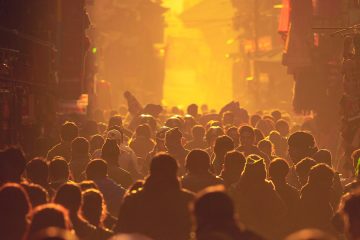 Crowded people backlit walking in street in yellow glow