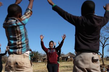 Kids in a group with their hands up