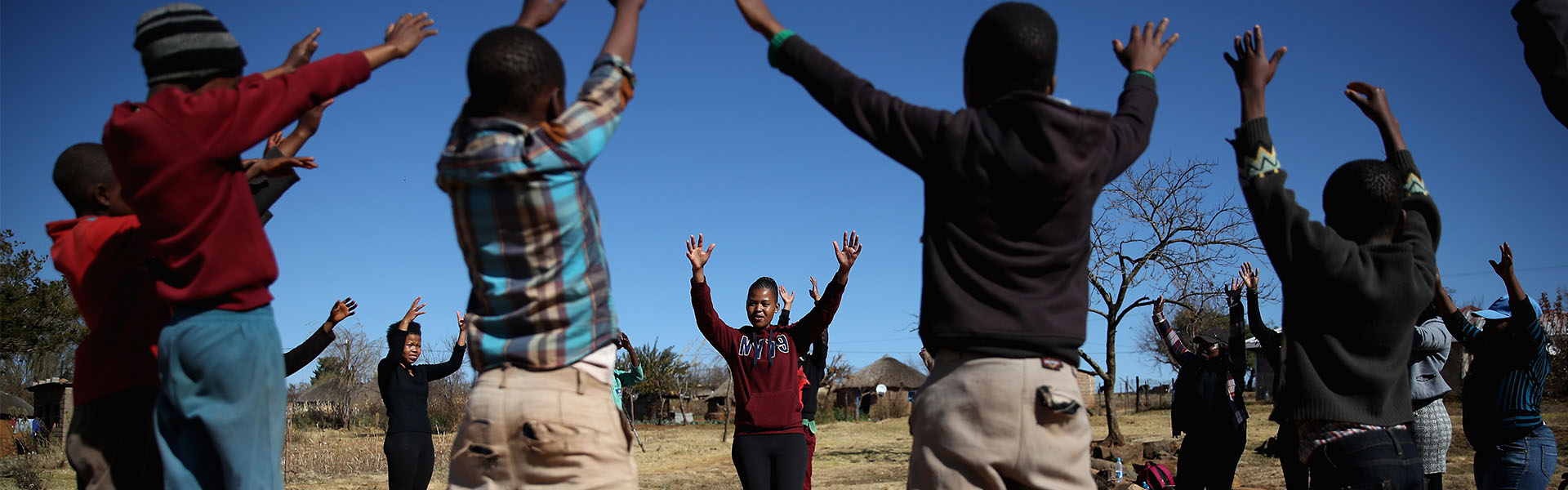 Kids in a group with their hands up