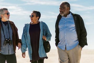 Two older men and woman walking and talking together