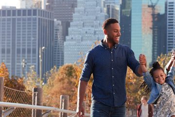 Couple walking with child with city tall buildings in the background