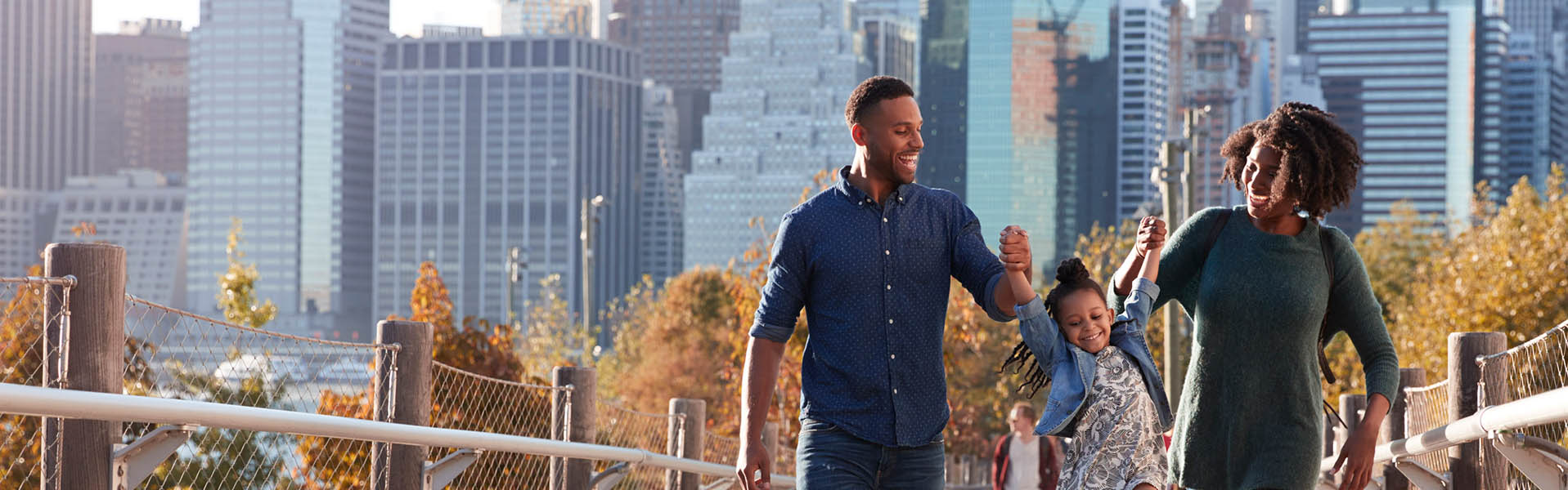 Couple walking with child with city tall buildings in the background