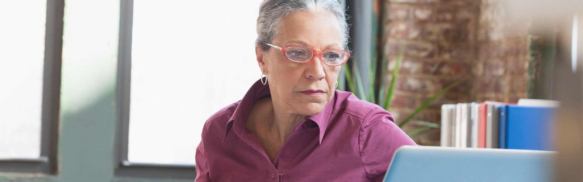 Hispanic businesswoman using laptop in office