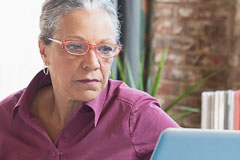 Hispanic businesswoman using laptop in office