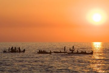 People on boats in the sunset