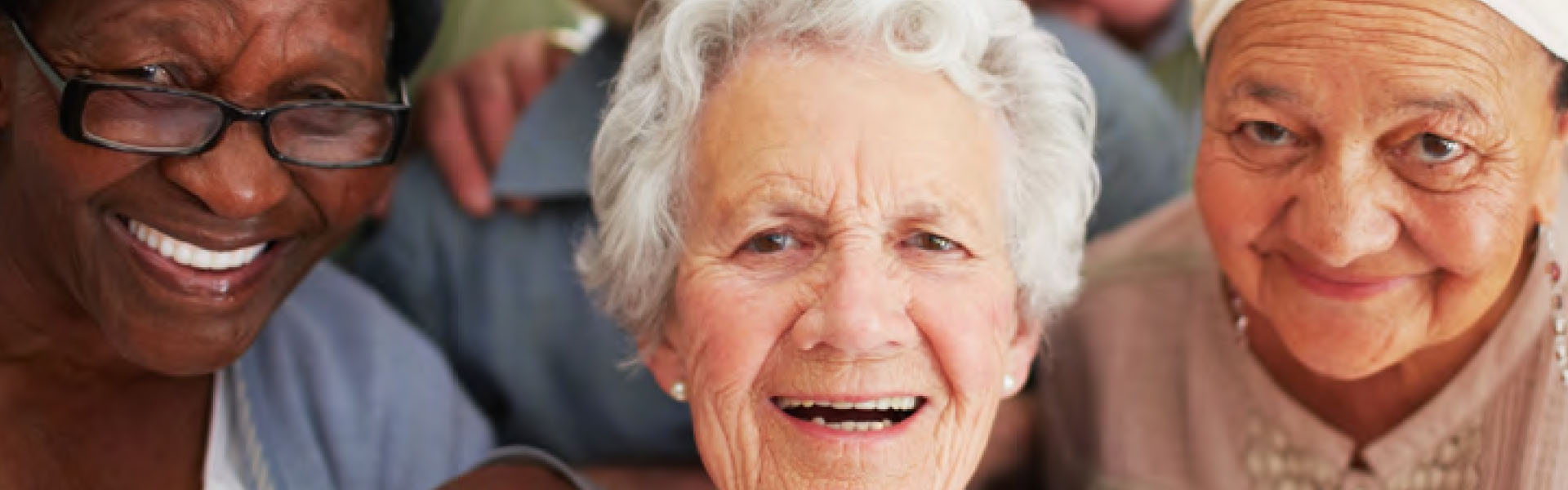 Three elderly women smiling at the camera