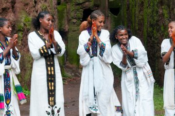 young women standing in a line clapping