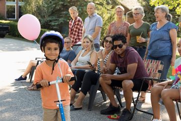 Child on a bike with crowd behind