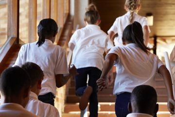 Young students running up stairs at the school