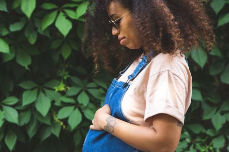 Pregnant afro hair woman in the city