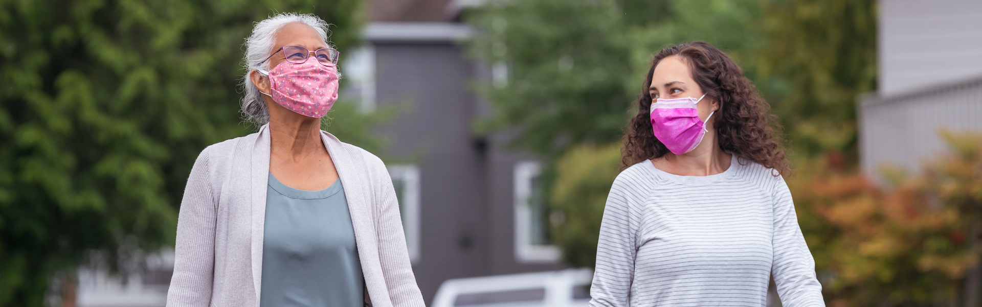 Two women wearing protective face masks enjoying the outdoors during Coronavirus