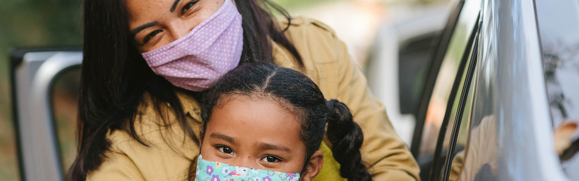 Portrait of mother and daughter wearing protective mask on the street