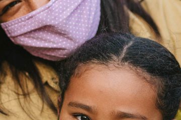 Portrait of mother and daughter wearing protective mask on the street