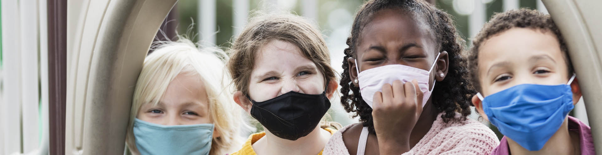 Children on playground wearing face masks, COVID-19