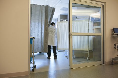 Doctor visits patient in hospital ward