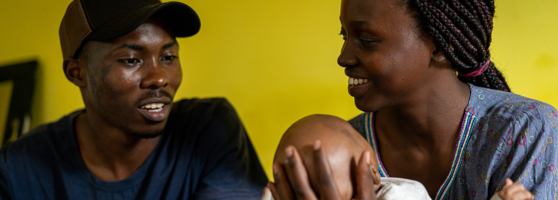 Black family with baby sitting on sofa