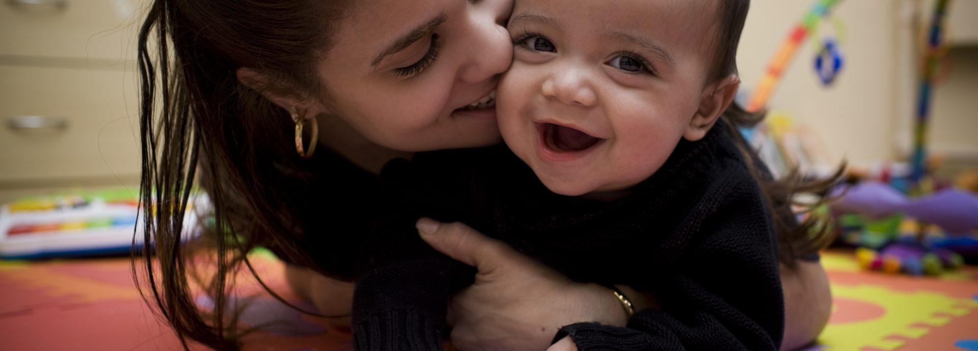 Adorable Hispanic Young Mother and Son in Home Playroom