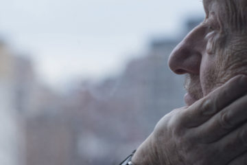 Man looking out of window, Manhattan, New York, USA