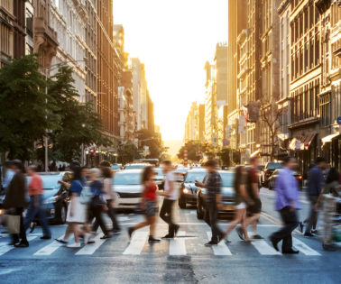 Crowds of people walking across a busy crosswalk at the intersection of 23rd Street and 5th Avenue in Manhattan New York City