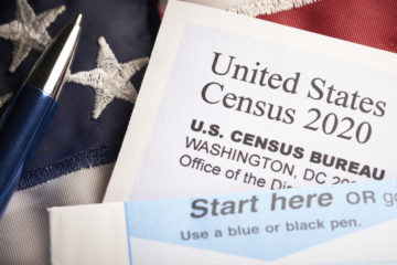 Census 2020: survey questionnaire form on desk with pen and usa flag