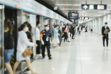 Crowd of busy commuters with protective face mask walking in beijing subway