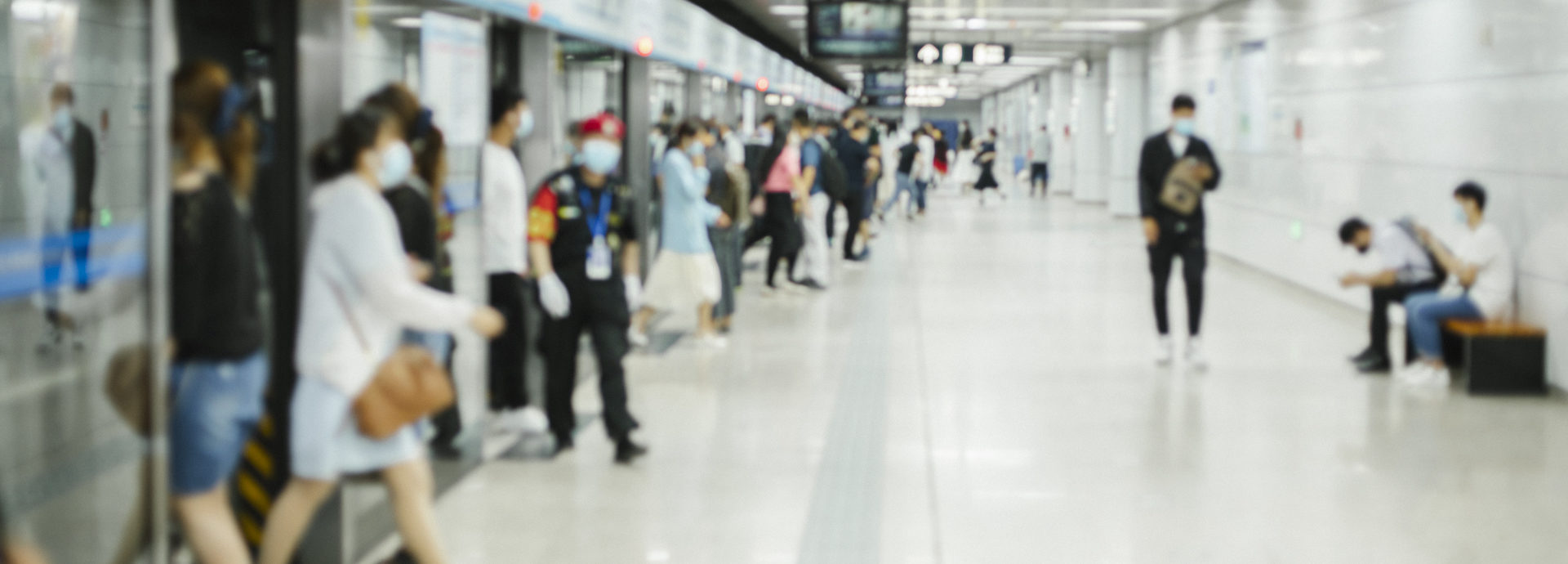 Crowd of busy commuters with protective face mask walking in beijing subway