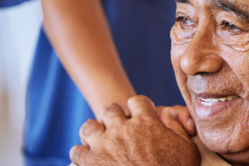 Nurse or doctor give man support during recovery or loss. Caregiver holding hand of her sad senior patient and showing kindness while doing a checkup at a retirement, old age home or hospital