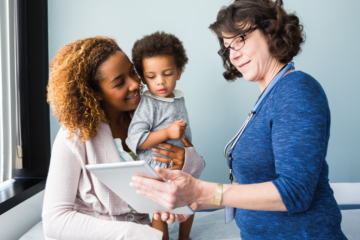 Doctor talks to mixed race mother and child.