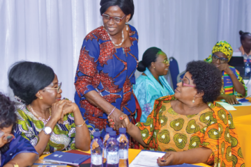 Members of REFAMP and other Togolese women's associations shake hands at the PRB and CREG meeting.