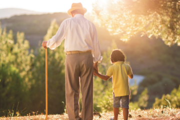 Old man and his grandson walk in the woods.