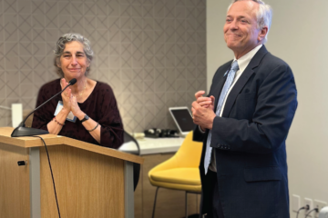 Jennifer Madans applauds for Jeff Jordan during his retirement party.