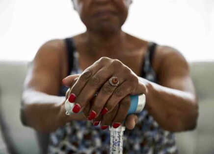 Hands of senior woman holding walking cane